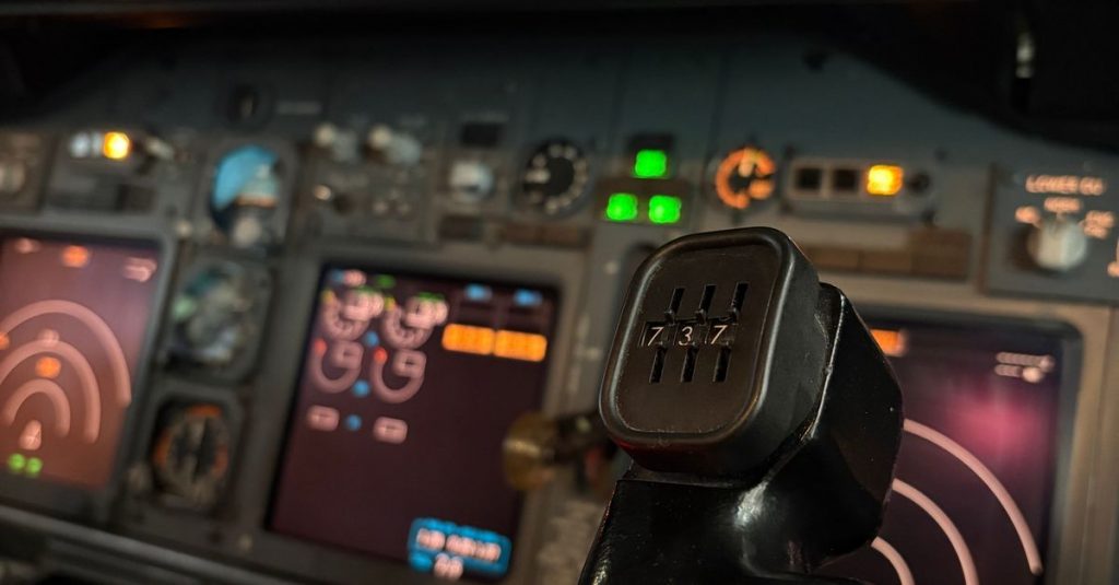 Detailed view of aircraft cockpit with control stick and digital displays, offering a glimpse into aviation technology.